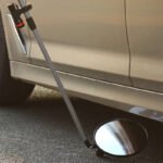 Miroir d’inspection sous véhicule avec poignée télescopique et roulettes, utilisé pour la sécurité et la détection d’objets sous les voitures.